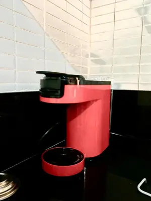 a red toilet with a black seat in a bathroom at Lovely Family aparts LAGUASSEM in El Gouassem