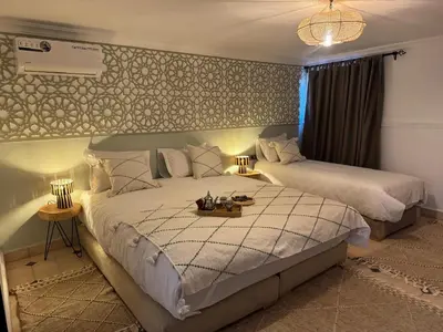 a bedroom with two beds with a table on it at Riad Douha in Marrakech