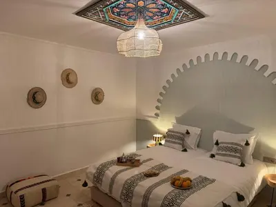 a bedroom with a king sized bed with a stained glass ceiling at Riad Douha in Marrakech
