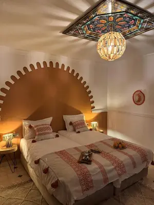 a bedroom with a large bed with a stained glass ceiling at Riad Douha in Marrakech