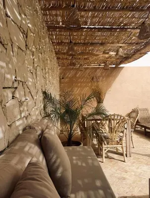 a person laying on a couch on a patio at Riad Darmoon in Marrakech
