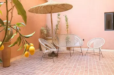 a patio with two chairs and a table and an umbrella at Duplex apart with parking by Sabor Voyage in Marrakech