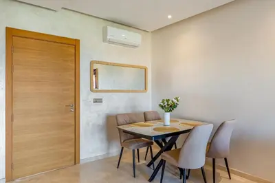 a dining room with a table and chairs and a door at Comfy Flat 2 BedRooms-Argan Golf Atlas View in Marrakech