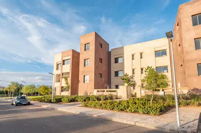 a pair of brick buildings on a street at Comfy Flat 2 BedRooms-Argan Golf Atlas View in Marrakech