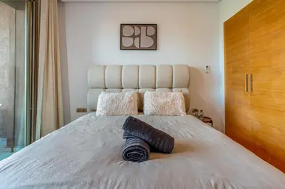 a bedroom with a large bed with a blanket on it at Comfy Flat 2 BedRooms-Argan Golf Atlas View in Marrakech