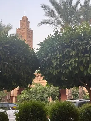 a view of a mosque with trees and a clock tower at Riad traditionnel Kham's centre Marrakech in Marrakech