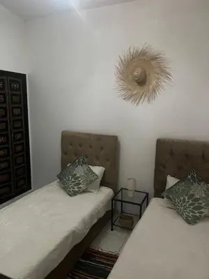 a bedroom with two beds and a mirror on the wall at Riad traditionnel Kham's centre Marrakech in Marrakech