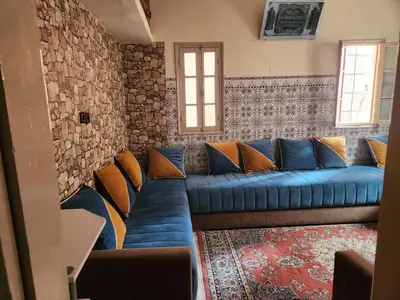 a blue couch in a room with a brick wall at Dar Damana in Marrakech