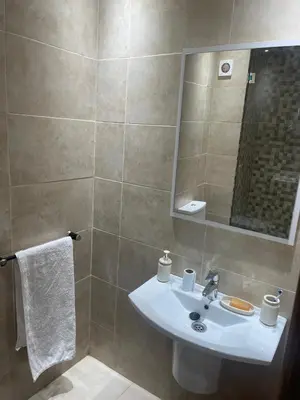 a bathroom with a sink and a mirror at Nour 5 Marrakech Appartement in Marrakech