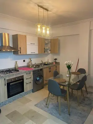 a kitchen with a table and chairs and a kitchen with a stove at Nour 5 Marrakech Appartement in Marrakech