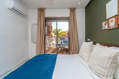 a bedroom with a bed and a window with a table at Modern Chic Apartment in Gueliz in Marrakech