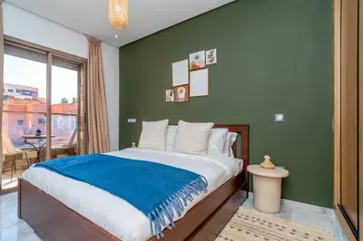 a bedroom with a large bed with a blue blanket at Modern Chic Apartment in Gueliz in Marrakech