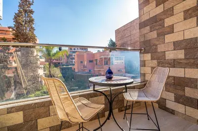 a balcony with a table and two chairs and a window at Modern Chic Apartment in Gueliz in Marrakech