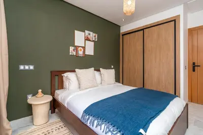 a bedroom with a large bed with a blue blanket at Modern Chic Apartment in Gueliz in Marrakech