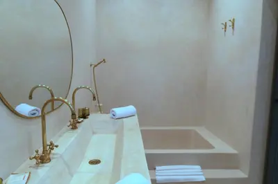 a bathroom with a tub and a sink and a mirror at Riad Sumud in Marrakech