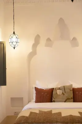 a bedroom with a bed and a chandelier at Riad Sumud in Marrakech