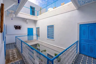 a room with a blue door and a balcony at Riad Les Secrets De Marrakech in Marrakech