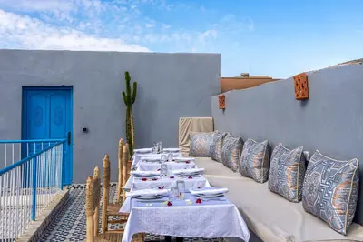 a row of tables with pillows on a patio at Riad Les Secrets De Marrakech in Marrakech