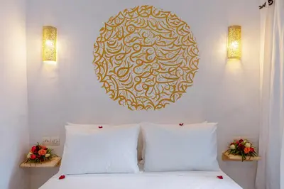 a bedroom with a bed with two pillows and a plate on the wall at Riad Les Secrets De Marrakech in Marrakech