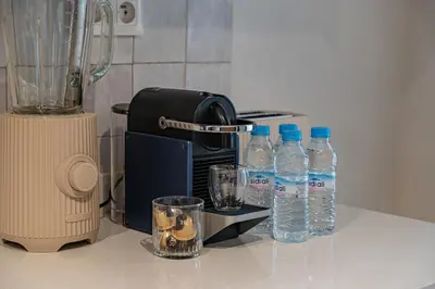 a counter with bottles of water next to a blender at Luxury Flat Private Rooftop & Heated Pool Guéliz in Marrakech