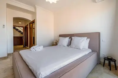 a bedroom with a large bed with white sheets at Luxury Flat Private Rooftop & Heated Pool Guéliz in Marrakech