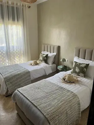a bedroom with two beds and a window at Résidence Atlas Golf Marrakech in Marrakech