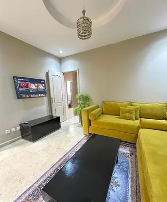 a living room with a yellow couch and a rug at apartment chic 2 chambers in Marrakech