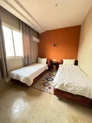 a bedroom with two beds and a window at apartment chic 2 chambers in Marrakech
