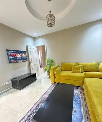 a living room with a yellow couch and a fireplace at apartment chic 2 chambers in Marrakech