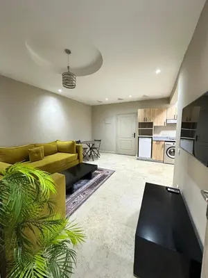 a living room with a yellow couch and a kitchen at apartment chic 2 chambers in Marrakech