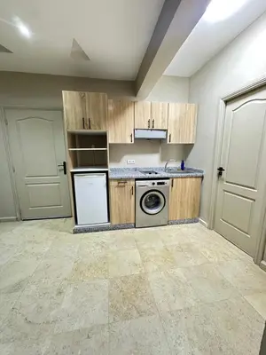 a kitchen with wooden cabinets and a washer and dryer at apartment chic 2 chambers in Marrakech