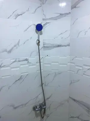 a bathroom with a shower with white marble walls at Majorelle City Apartment in Marrakech