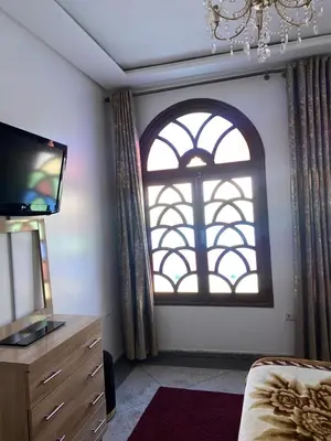 a room with a window and a dresser and a television at Majorelle City Apartment in Marrakech