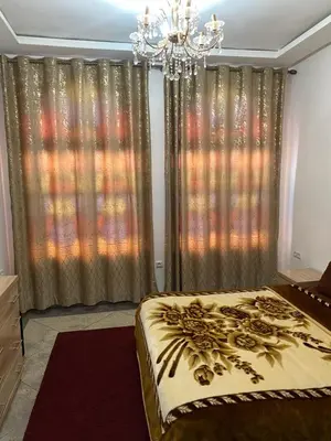 a bedroom with a large bed and a chandelier at Majorelle City Apartment in Marrakech