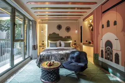 a bedroom with a bed and a chair and a table at Riad Kalemat & Spa in Marrakech