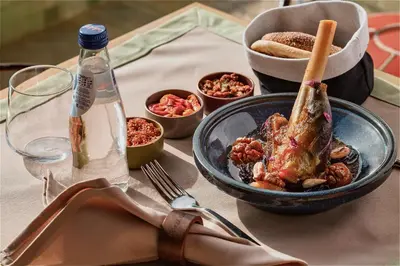a table with a plate of food and a bowl of meat at Riad Kalemat & Spa in Marrakech