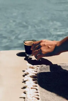 a person holding a cup of coffee on the beach at Riad Kalemat & Spa in Marrakech