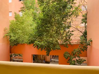 an orange wall with trees in front of a building at Lovely Studio a gulez centre marrakech in Marrakech