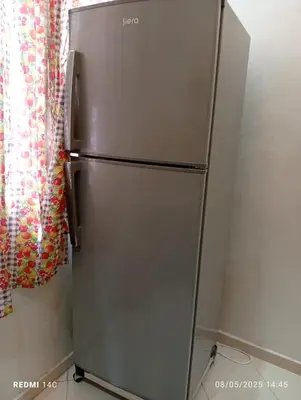 a stainless steel refrigerator in a kitchen next to a curtain at Appartement familial à Marrakech in Marrakech