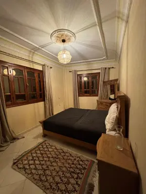 a bedroom with a large bed and a chandelier at Comfortable stay - Marrakech style in Marrakech