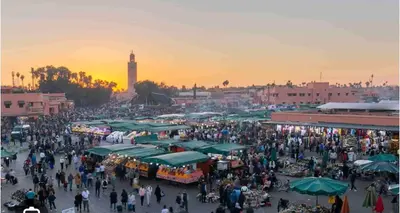 a crowd of people walking around a market at sunset at Comfortable stay - Marrakech style in Marrakech