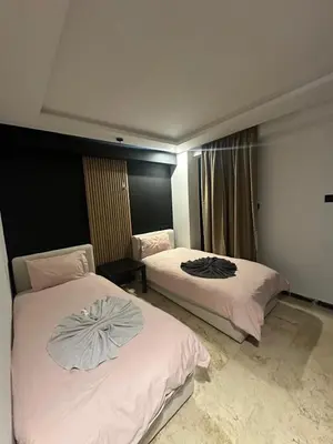 a hotel room with two beds with towels on them at le duplex spacieux comfort in Marrakech