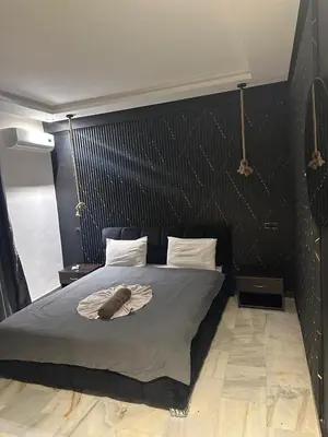 a bedroom with a large bed with a black headboard at le duplex spacieux comfort in Marrakech