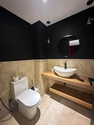 a bathroom with a white toilet and a sink at le duplex spacieux comfort in Marrakech
