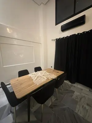 a wooden table with chairs in a room at le duplex spacieux comfort in Marrakech