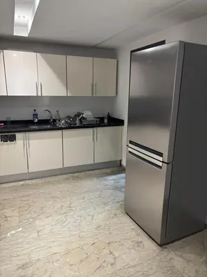 a stainless steel refrigerator in a kitchen with white cabinets at Menara Garden Gueliz Marrakech in Oulad Akkou