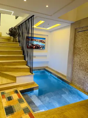 a swimming pool in the middle of a room with stairs at RIAD El Ma in Marrakech