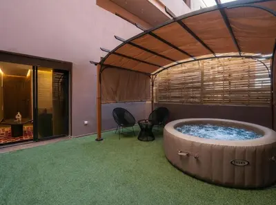 a hot tub in a room with chairs and a table at Jacuzzi Private Terrace Design Central Apartment in Marrakech