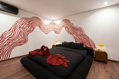 a bedroom with a black couch in front of a wall at Jacuzzi Private Terrace Design Central Apartment in Marrakech