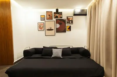 a bedroom with a black bed with pictures on the wall at Jacuzzi Private Terrace Design Central Apartment in Marrakech